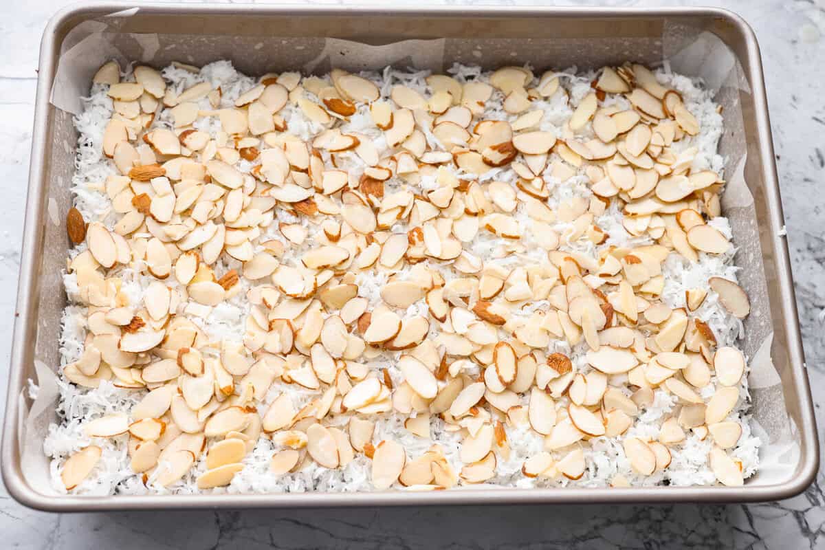 Sliced almonds layered over the top of the coconut. 