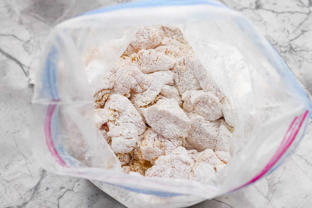 Skip the takeout and make this easy baked General Tso’s chicken at home! It’s crispy, saucy, and perfectly sweet with just the right amount of heat, no deep fryer required. Egg washed chicken covered in cornstarch in a zip loc bag.