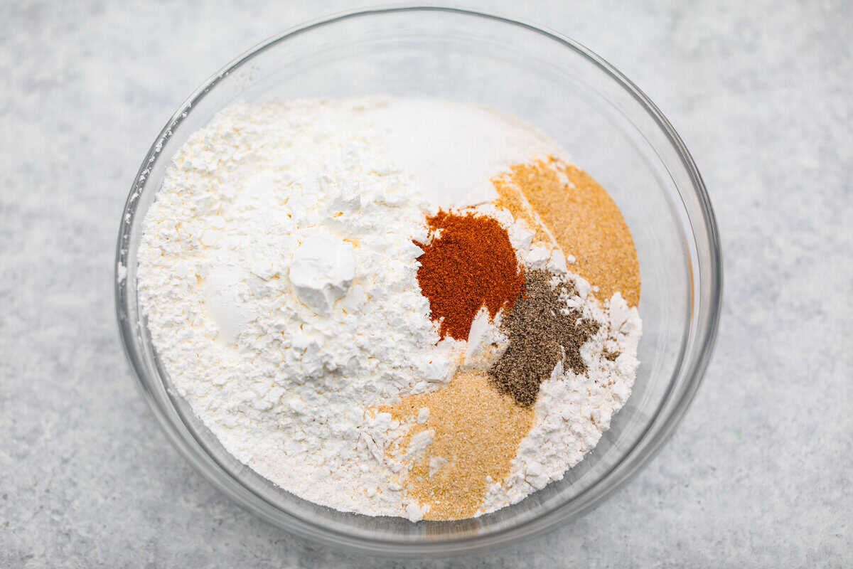 Flour and seasonings added to a mixing bowl.