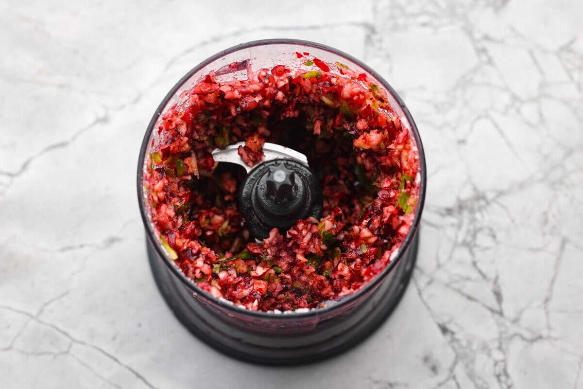 Cranberries, onions, jalapeños, sugar, and lime juice in a food processor.