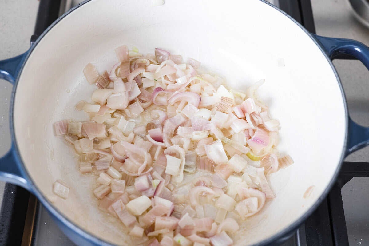 Shallots cooking in butter in a skillet.
