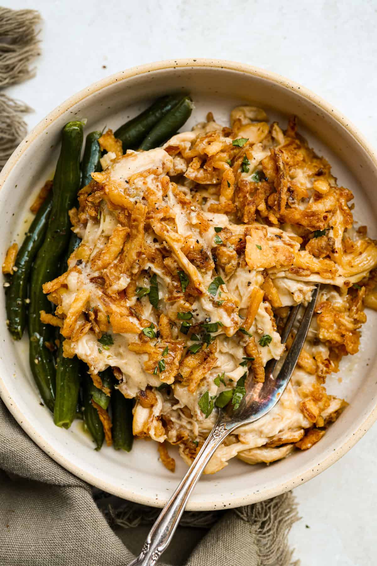 Plated French onion chicken casserole with a side of green beans. 